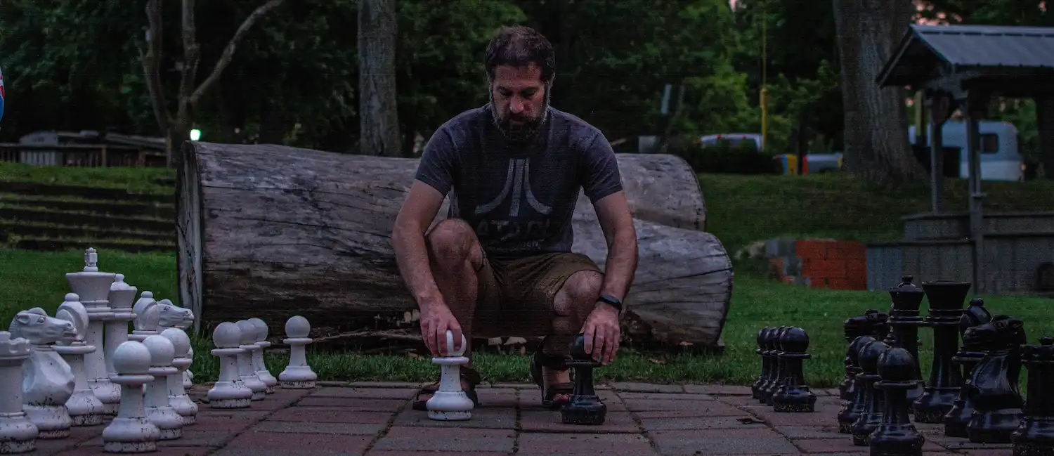 Chris Weed leaning over an oversized Chess board